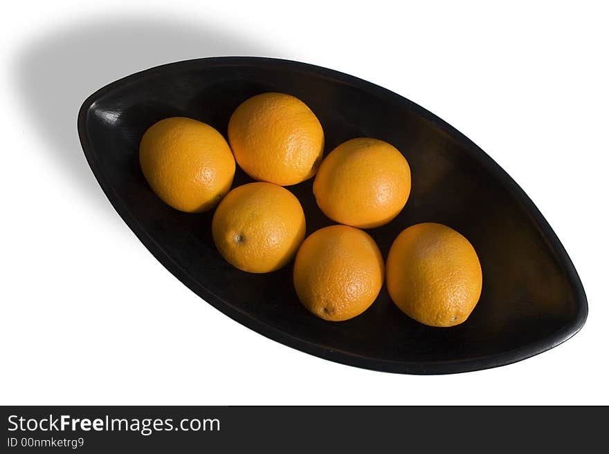 Close-up of black Japanese vase with oranges in white background in areal view. Close-up of black Japanese vase with oranges in white background in areal view