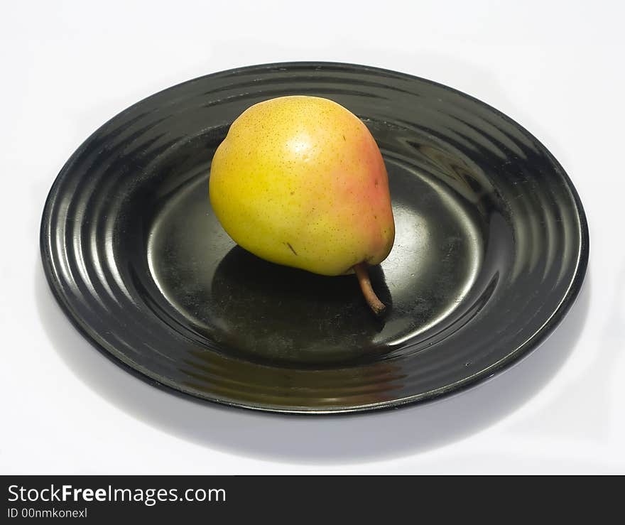 Close-up of fresh pear on a black plate