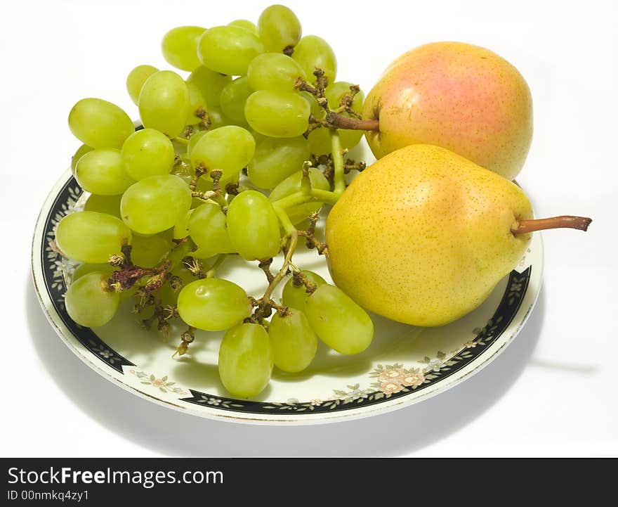 Plate with pears and grapes with shadow on white background