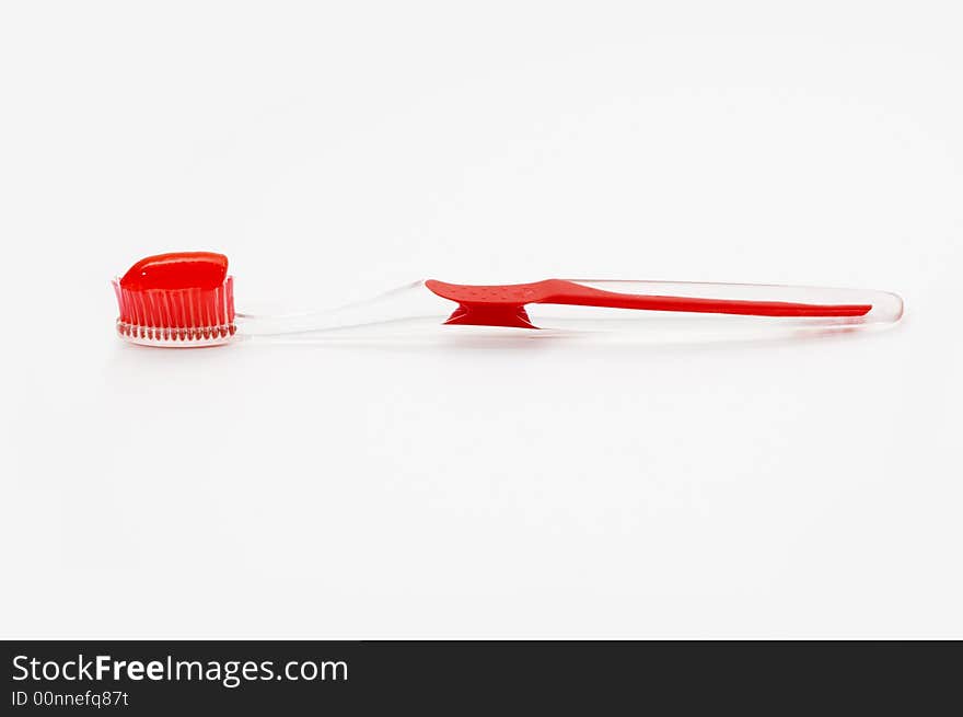 Red toothbrush with toothpaste isolated. Red toothbrush with toothpaste isolated