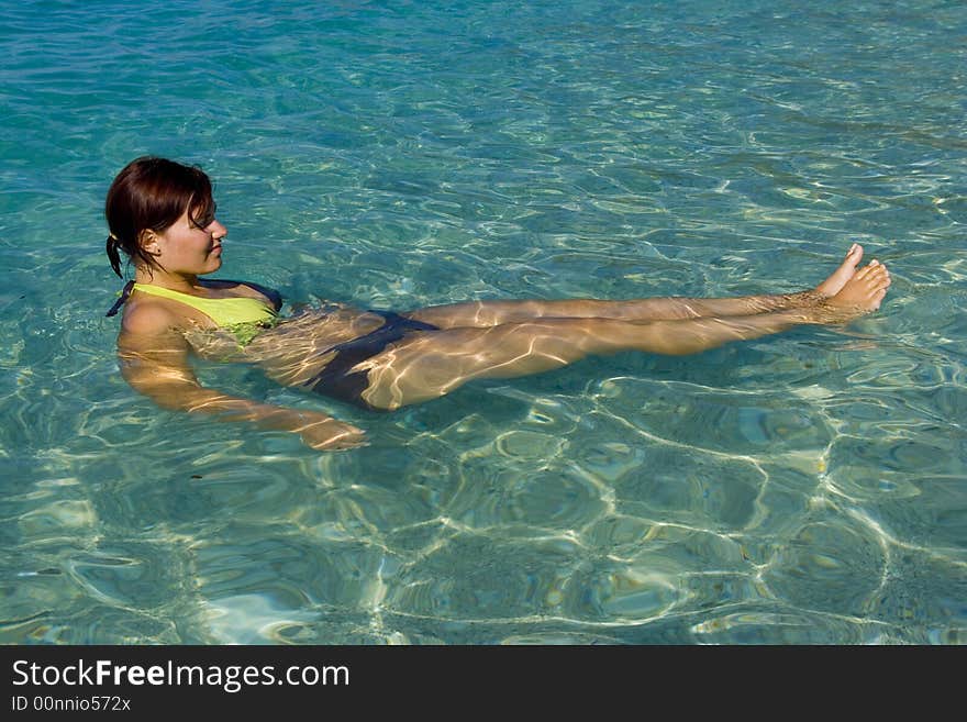 Young woman is relaxing on a blue water level of beautiful Ionian Sea. Young woman is relaxing on a blue water level of beautiful Ionian Sea.