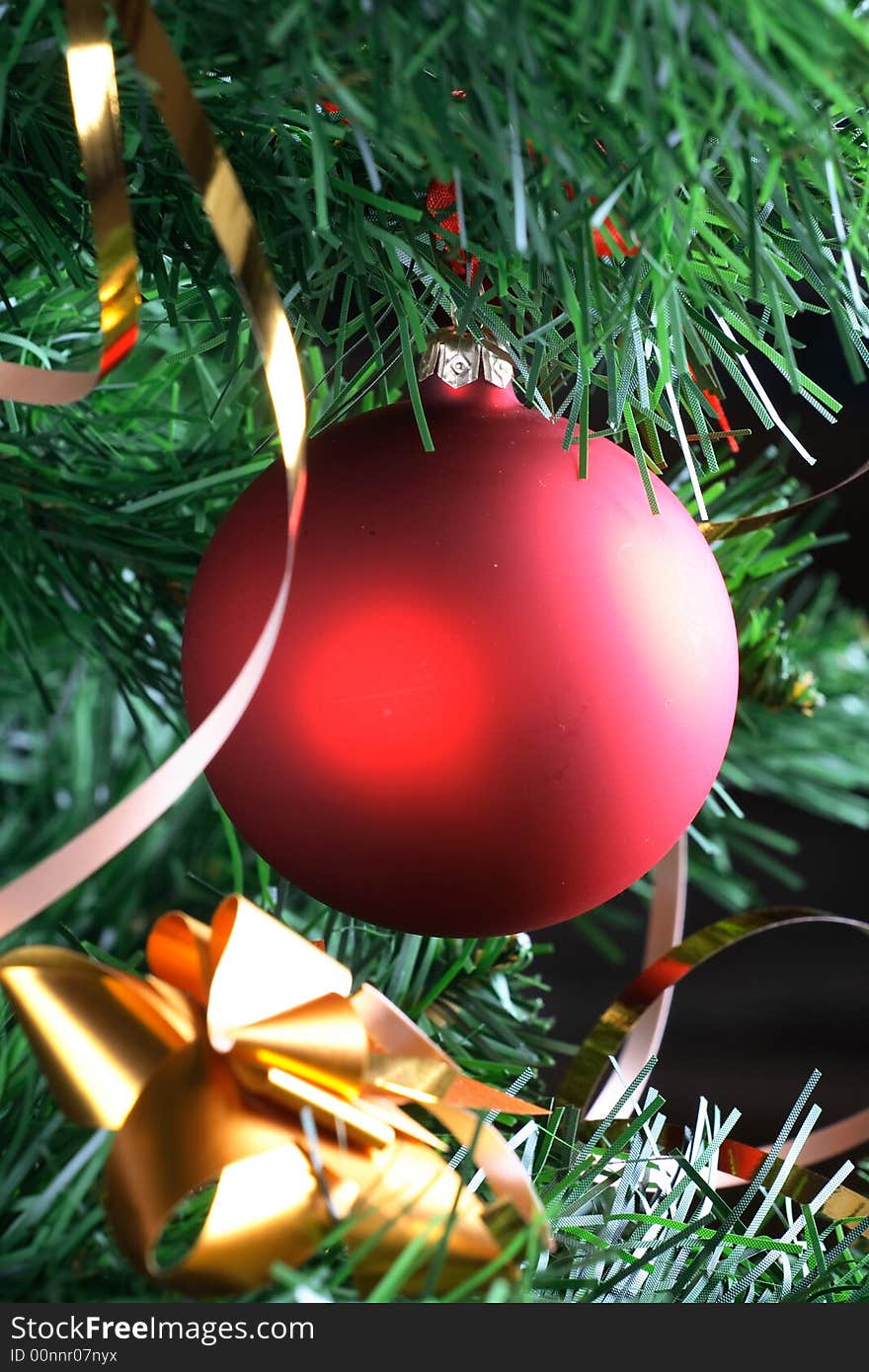 Red ball hanging from christmas tree.