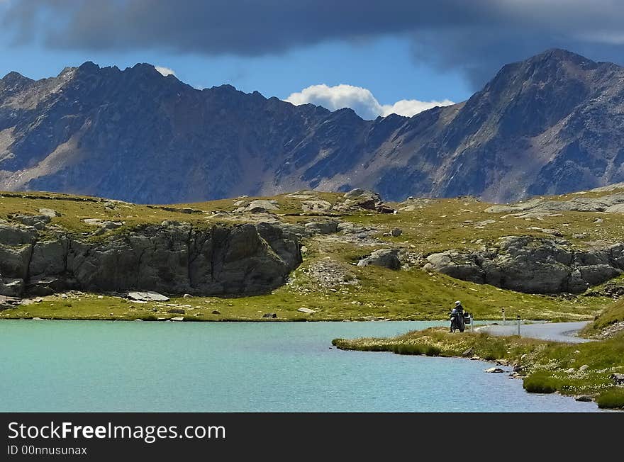 Lake and motorbike driver in the Italian Alps. Lake and motorbike driver in the Italian Alps