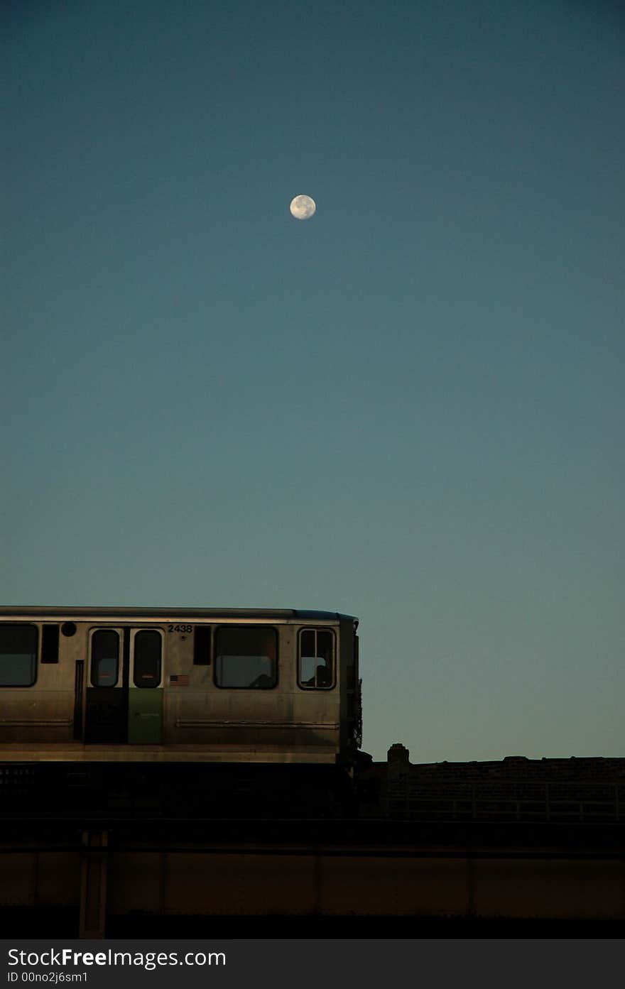 Moon over train at dawn as the sun rises