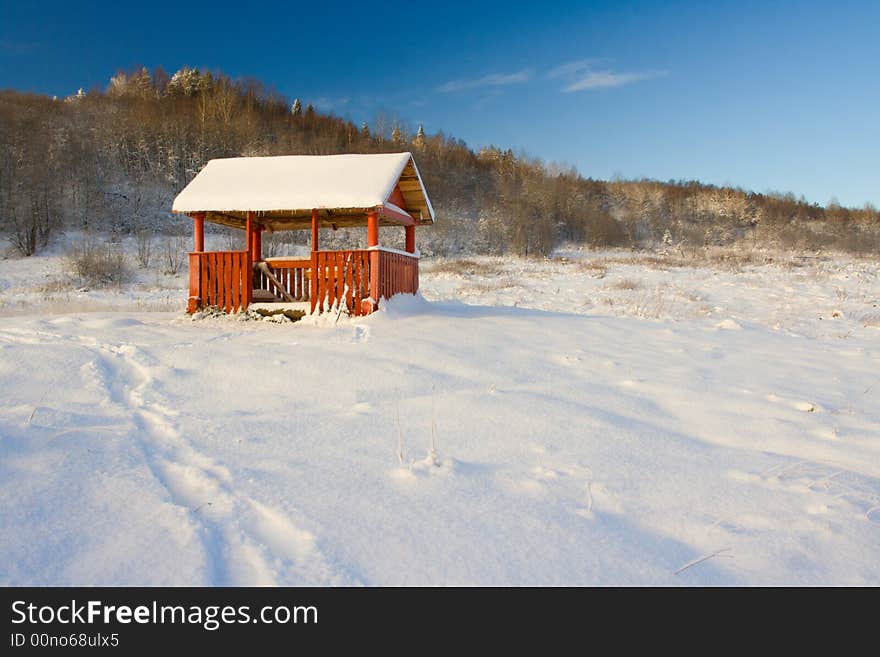 Small pergola in a snow at a high hill