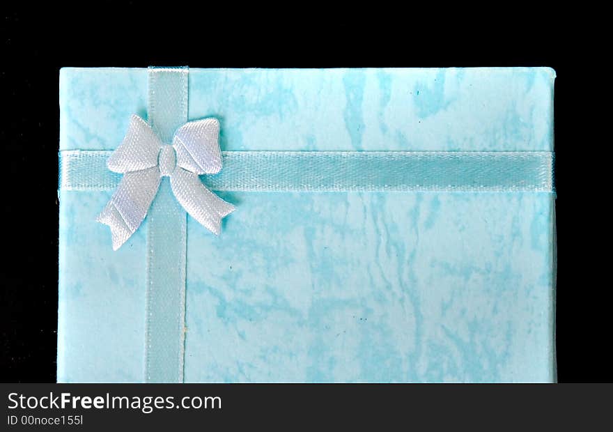 Blue gift box with ribbon on black isolated