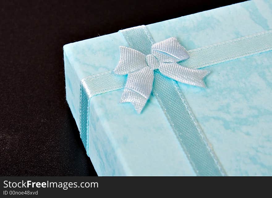 Blue gift box with ribbon on black ISOLATED. Blue gift box with ribbon on black ISOLATED