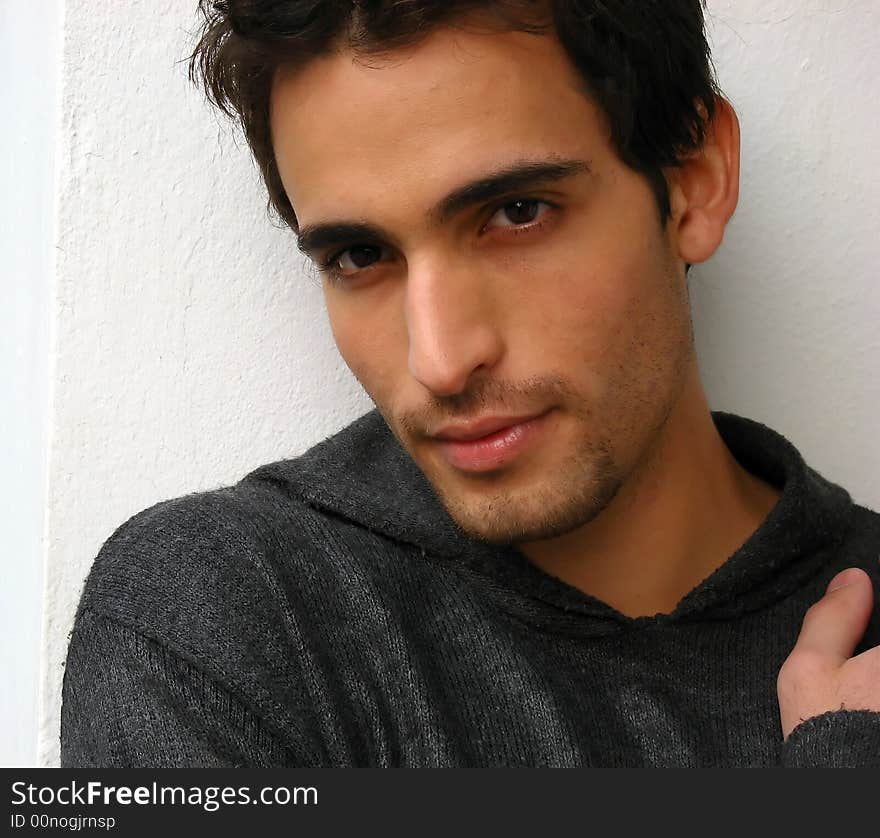 A young man looking at the camera outdoors, isolated