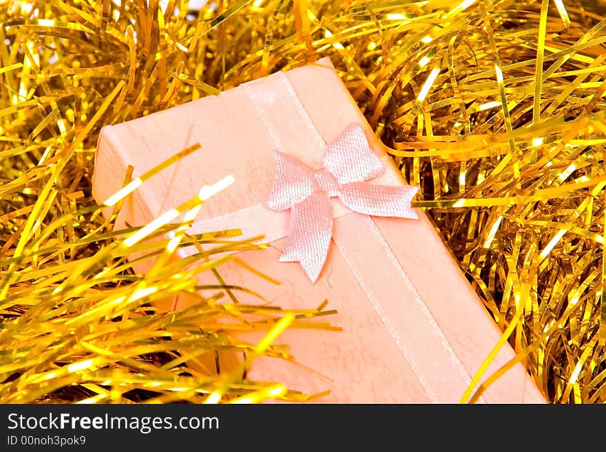 Pink Christmas gift with ribbon on gold  decorations. Pink Christmas gift with ribbon on gold  decorations