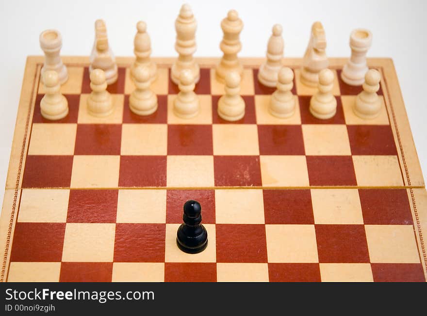 A carved marble chess board and wooden chess pieces. Focus to foreground.