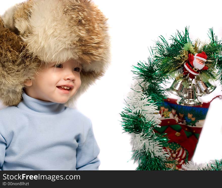 Little child in hat near christmas tree. Little child in hat near christmas tree