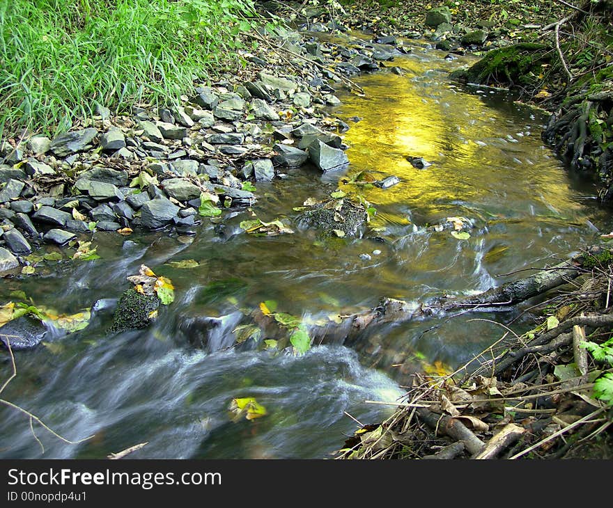 Beautiful sunrise mirroring in a brook with long exposure. Beautiful sunrise mirroring in a brook with long exposure