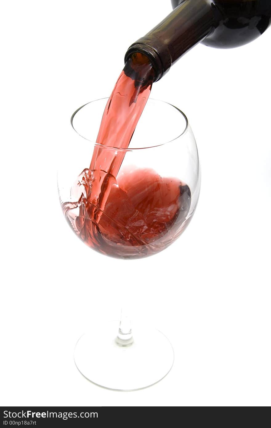 Pouring red wine from a bottle isolated against white background