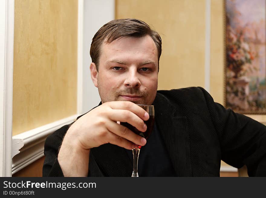 The man with glass posing at restaurant