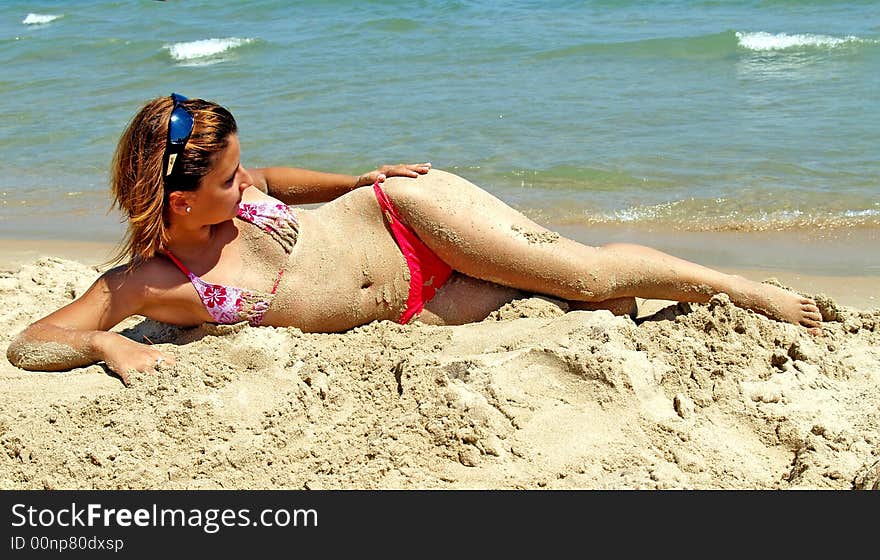 Teenager posing in the sand near the sea