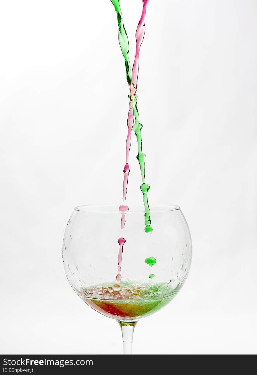 Red and green  fluid  mixing in the glass . Red and green  fluid  mixing in the glass