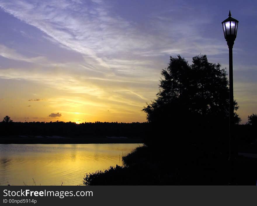 Street lamp and sunset at lake shore