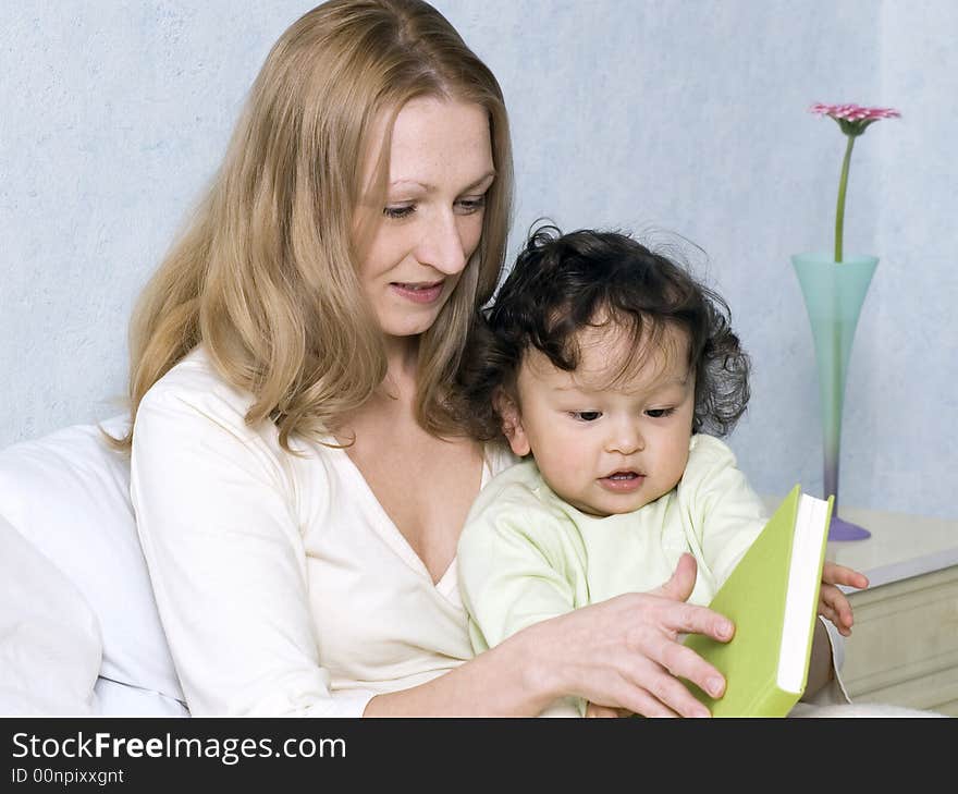 Mother reads to the child the book. Mother reads to the child the book.