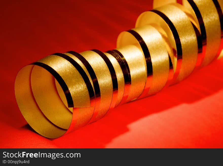 Golden curly ribbon on red background. Golden curly ribbon on red background