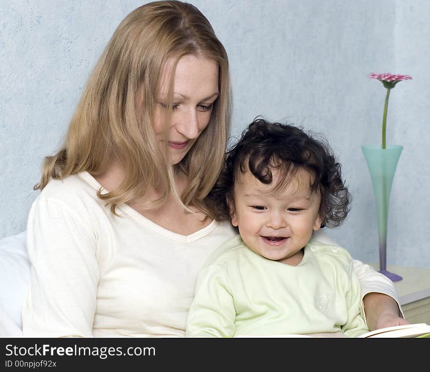 Mother reads to the child the book. Mother reads to the child the book.