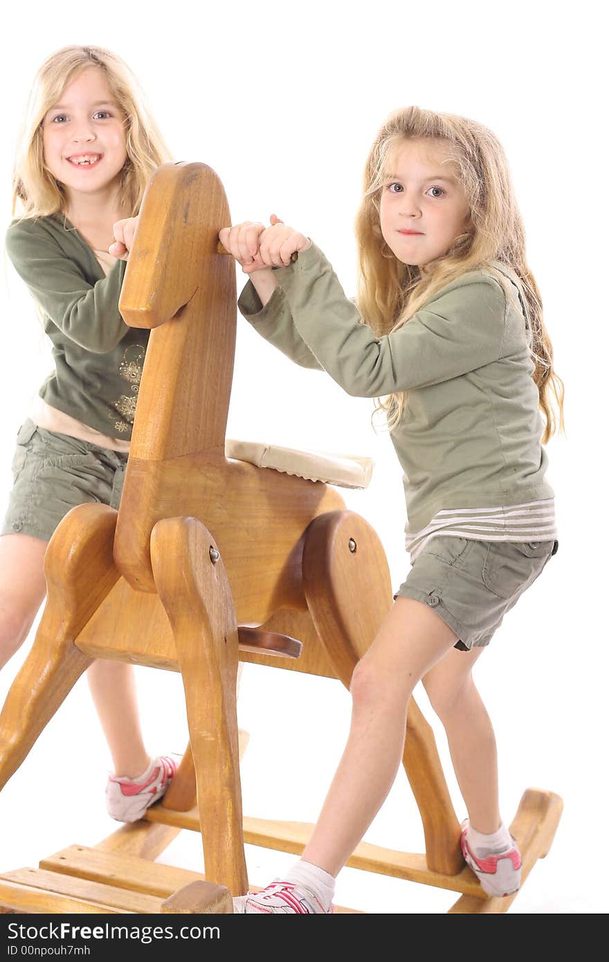 Twin children sharing a big rocking horse