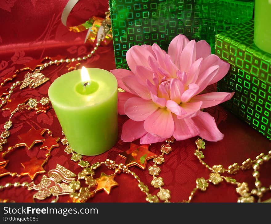 Celebration table (candles, flowers and gift on red background)