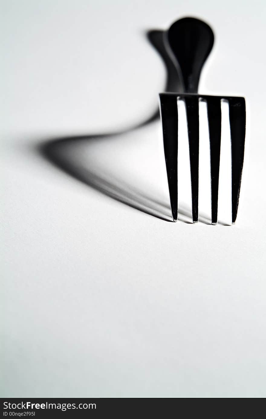 High contrast close-up of a fork with defined shadows. High contrast close-up of a fork with defined shadows