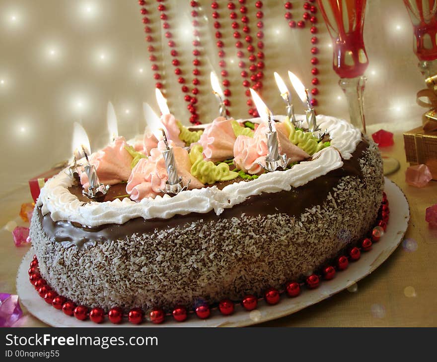 Celebratory table (cake and candles, two glasses with champagne, gift boxes)