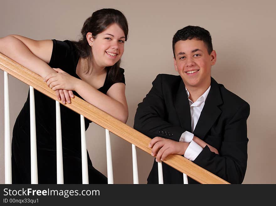 A sister and brother all dressed up and posing for the camera. A sister and brother all dressed up and posing for the camera.