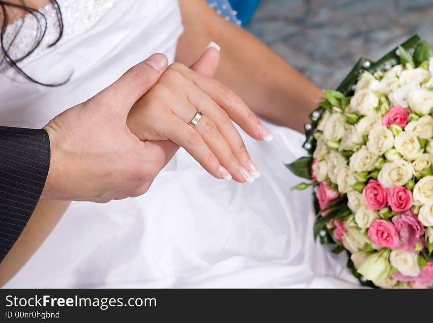 Hands with gold rings and flower bouquet