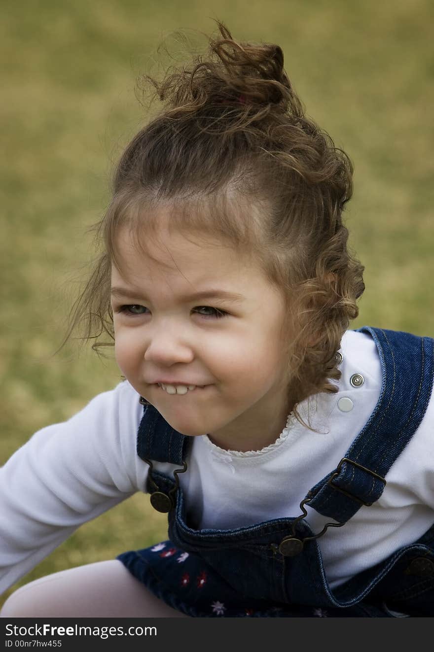 Young girl on grass with a funny smile. Young girl on grass with a funny smile.