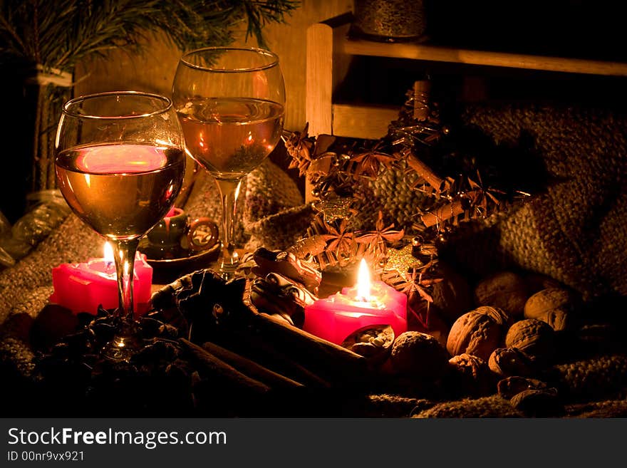 Christmas still-life - candles, cookies, cones, nuts and spices with two glasses of wine. Christmas still-life - candles, cookies, cones, nuts and spices with two glasses of wine