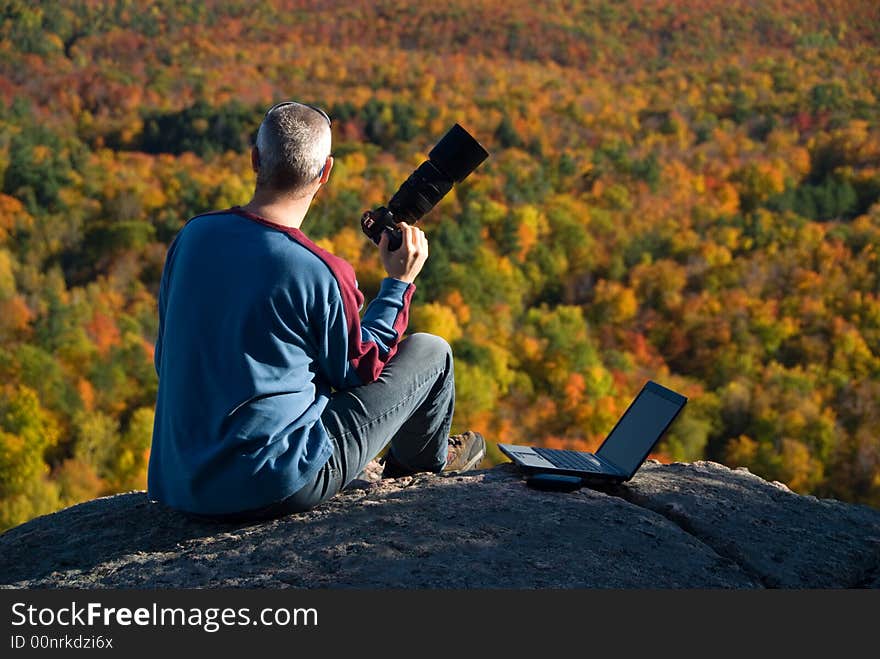 Male photographer shooting at the top of a mountain. Male photographer shooting at the top of a mountain