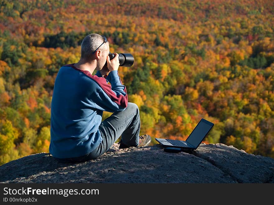 Male photographer shooting at the top of a mountain. Male photographer shooting at the top of a mountain