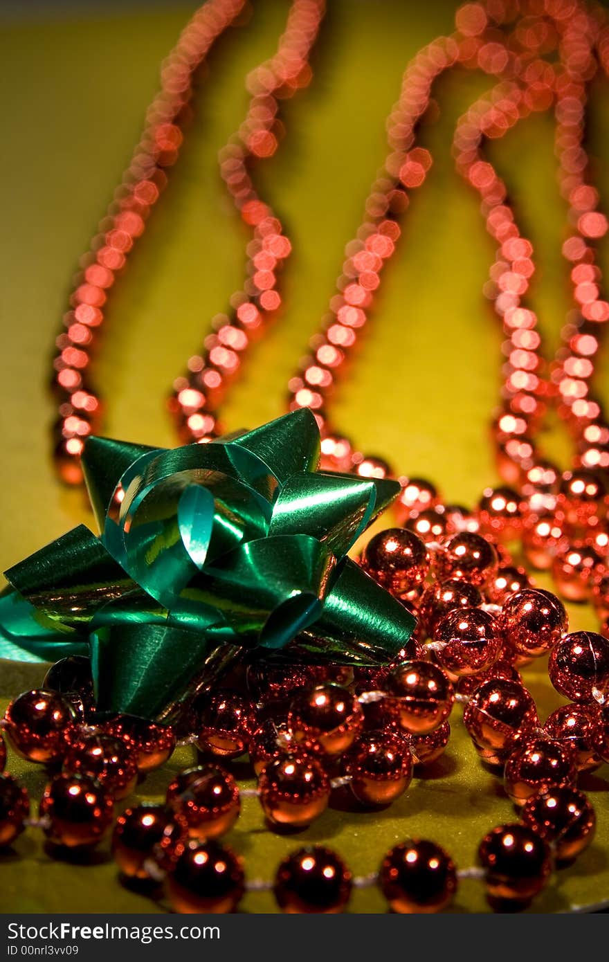 Red christmas beads for tree decoration shot on a gold background