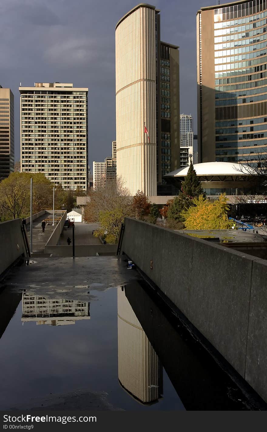 Strong lines of Toronto City Hall reflected in standing water. Strong lines of Toronto City Hall reflected in standing water