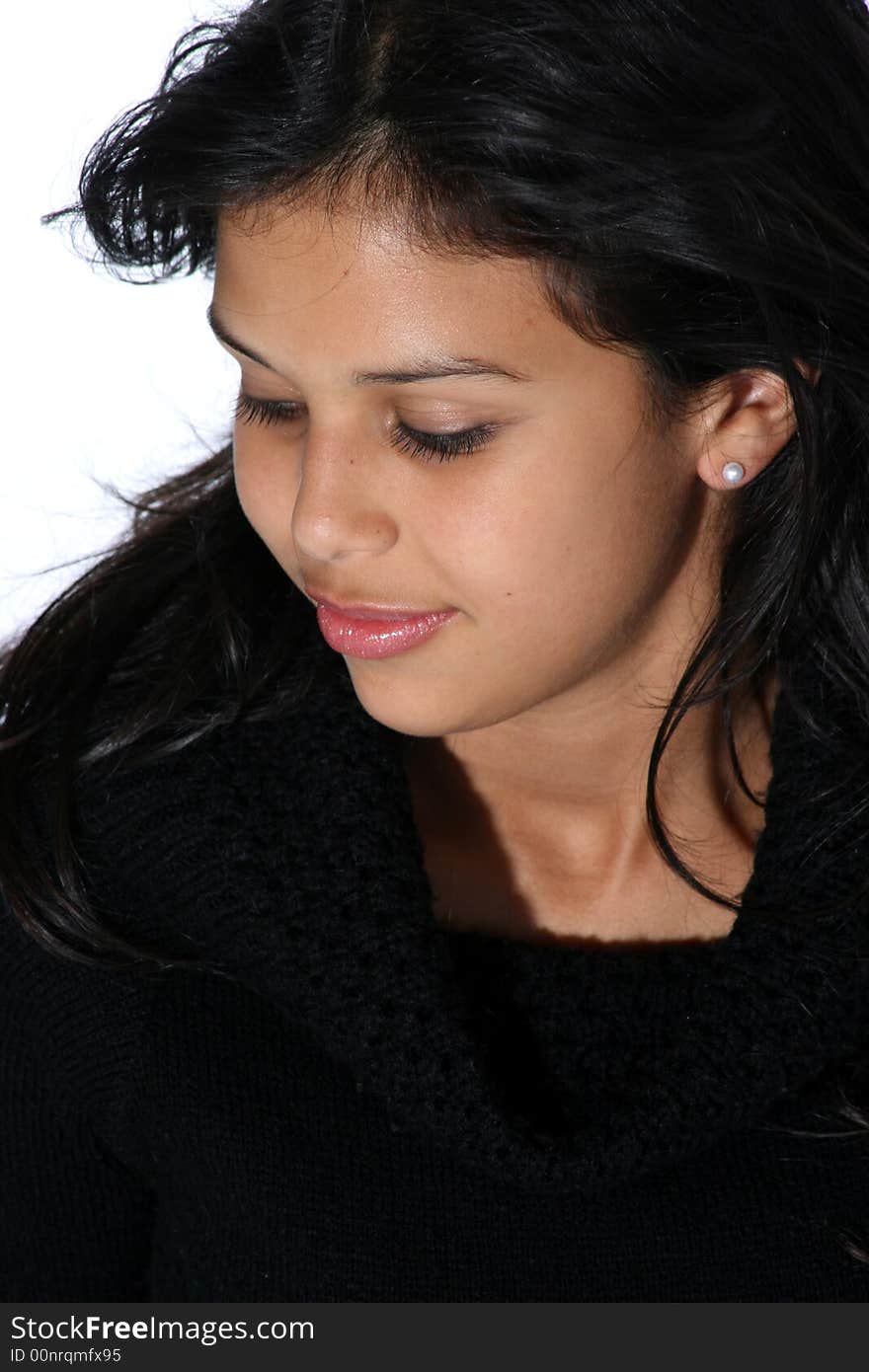 Portrait of attractive young woman in black sweater looking down shyly. Portrait of attractive young woman in black sweater looking down shyly