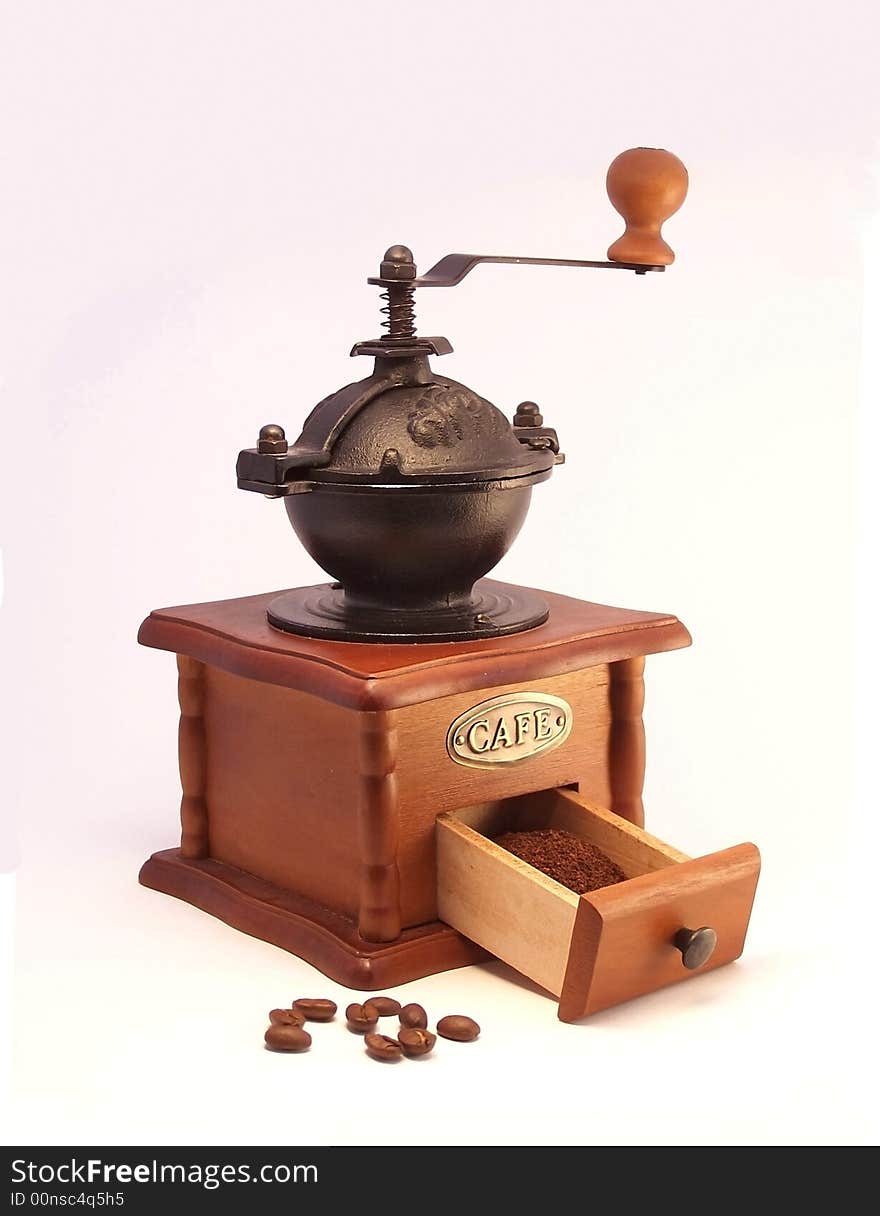 Wooden coffee mill and coffee beans on a white background. Wooden coffee mill and coffee beans on a white background.