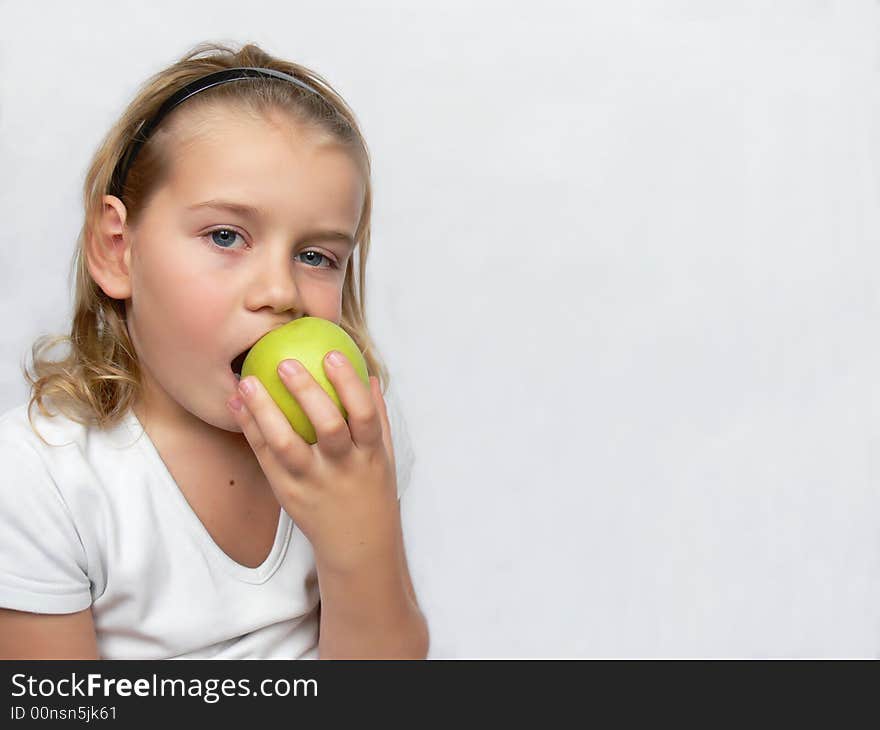 An adorable boy is holding a green apple. An adorable boy is holding a green apple.