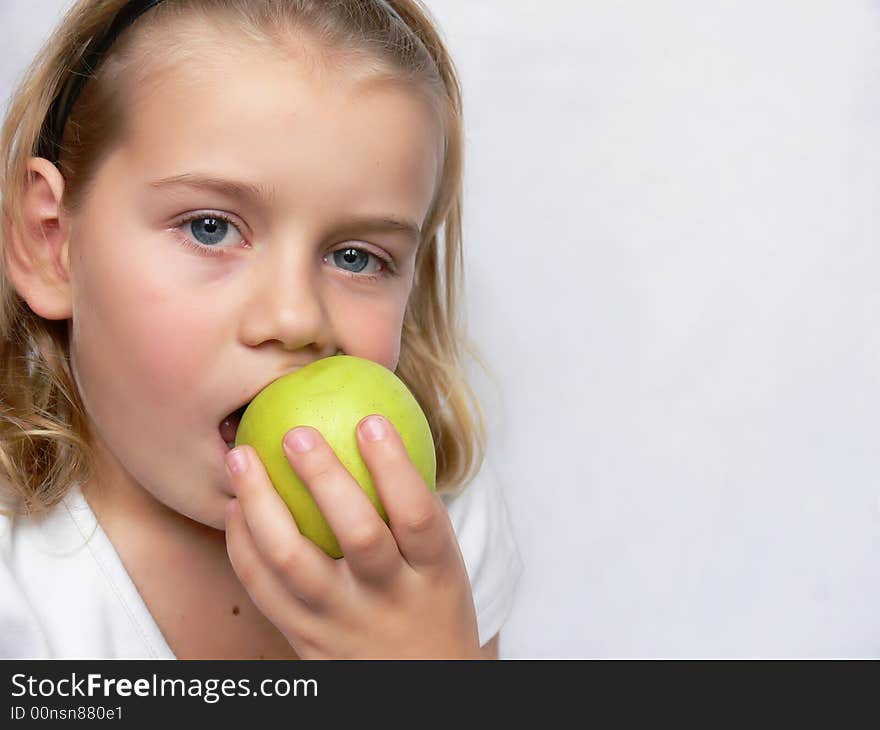 An adorable boy is holding a green apple. An adorable boy is holding a green apple.