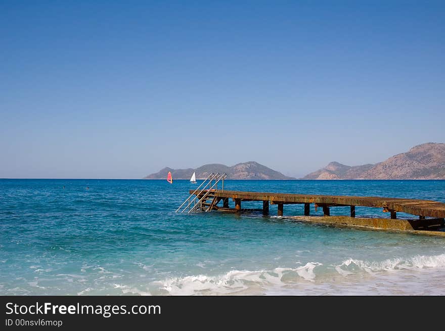 Photo of planked footway goes far in the sea. Photo of planked footway goes far in the sea