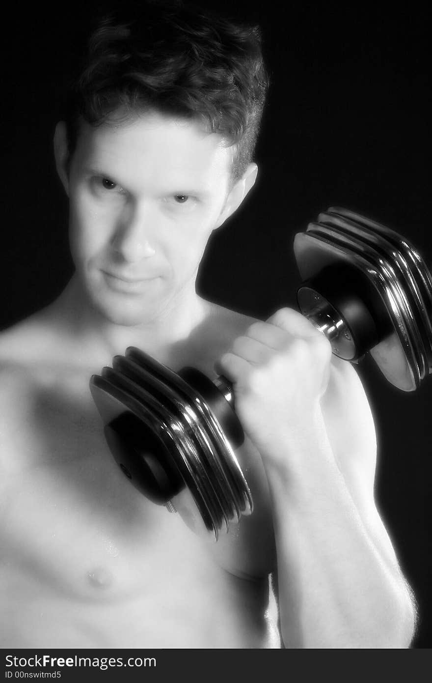 Atractive 30 something man lifting weights over black. Atractive 30 something man lifting weights over black.