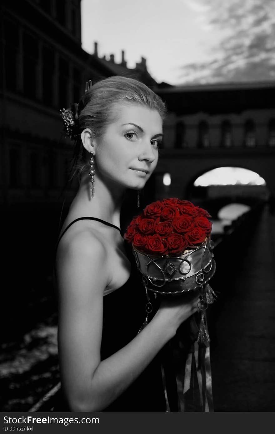 Black and white picture of a beautiful girl with roses  in old city