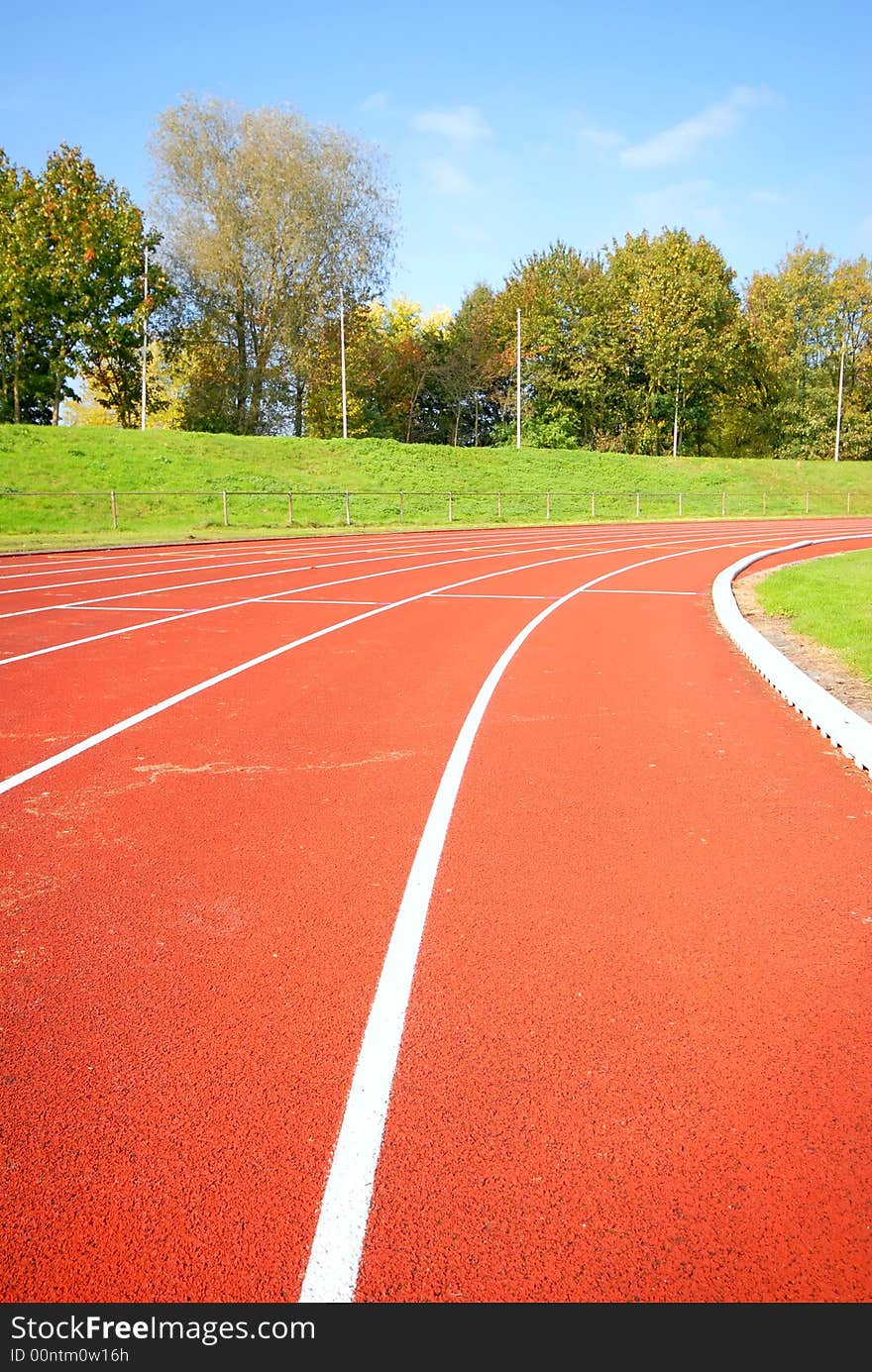 Racetrack, red tarmac, for runners. trees in the background. Racetrack, red tarmac, for runners. trees in the background