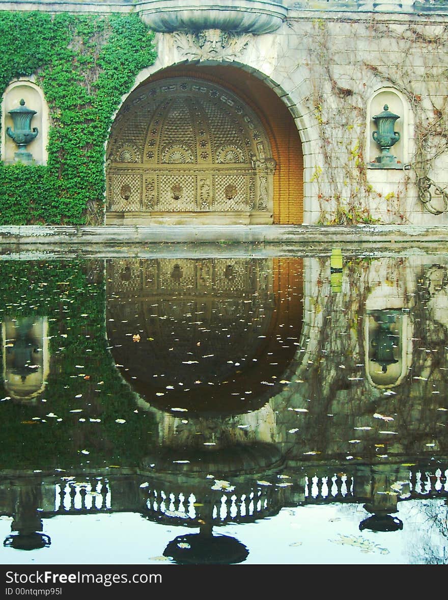 Part of historic building and its reflection in puddle. Part of historic building and its reflection in puddle.