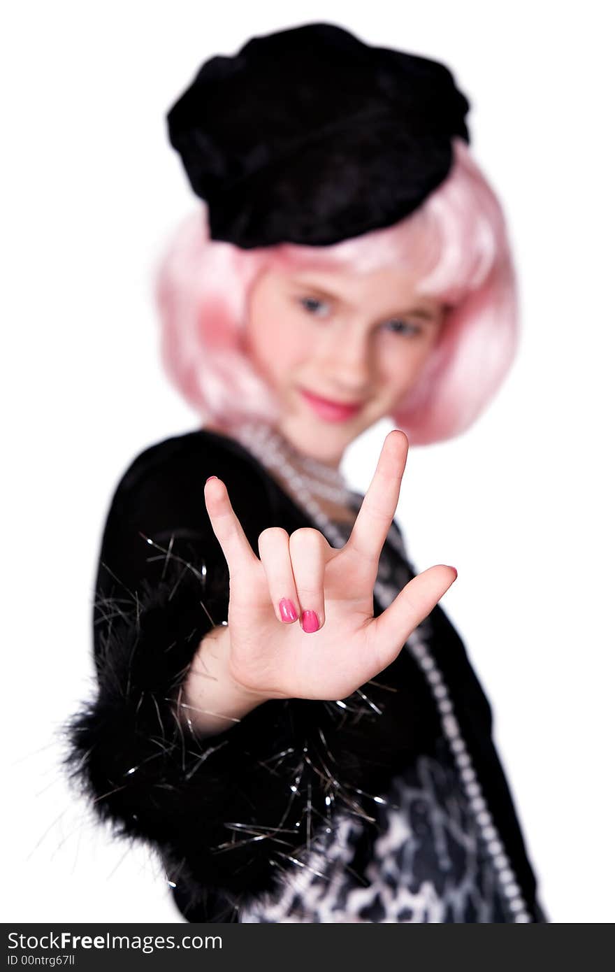 Preteen with pink hair and dressed as a diva signing I Love You.  Shallow DOF with focus on hand.