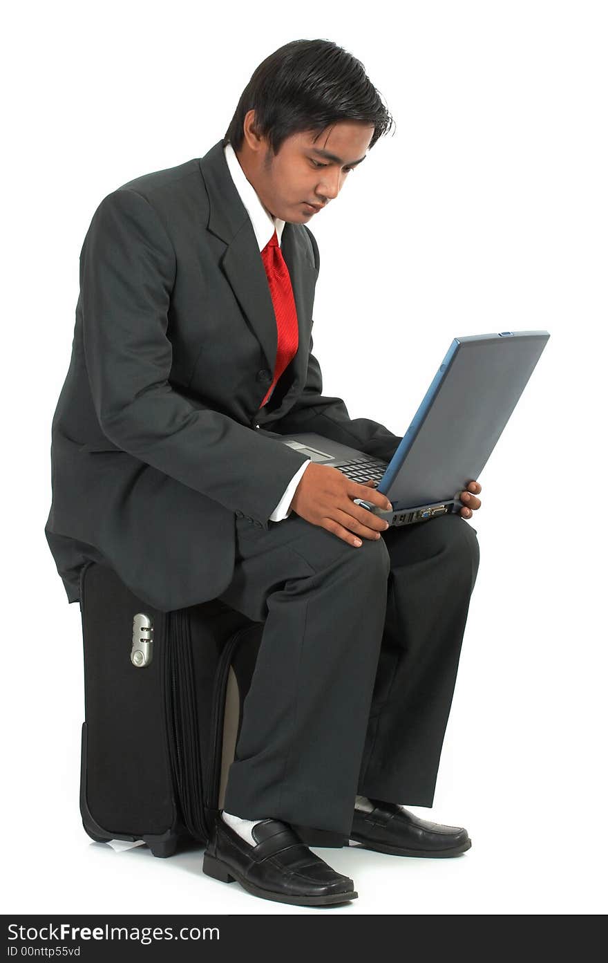 A man sitting on his luggage over a white background. A man sitting on his luggage over a white background