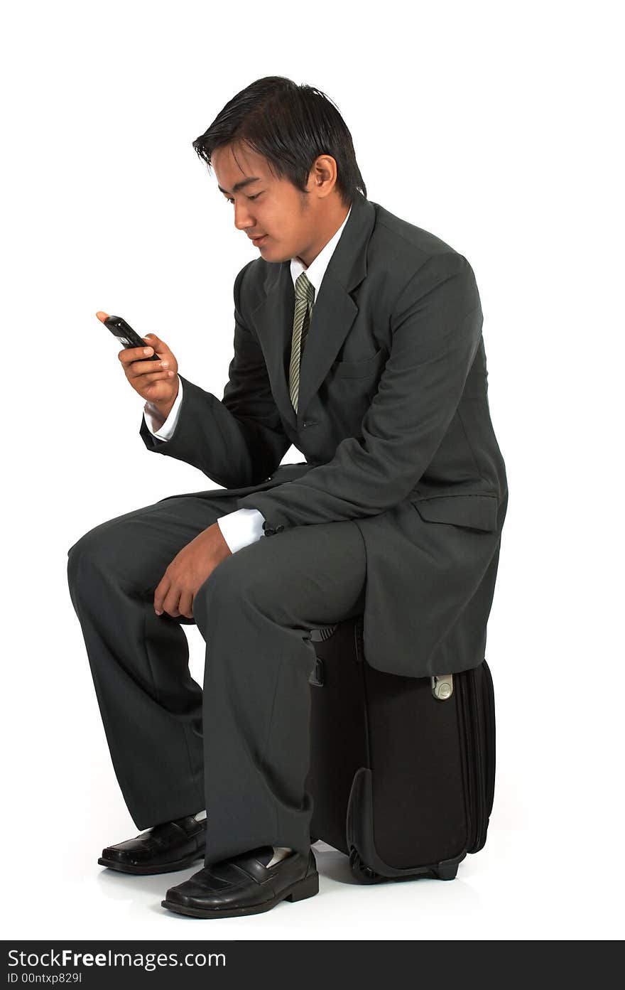 A man sitting on his luggage over a white background. A man sitting on his luggage over a white background