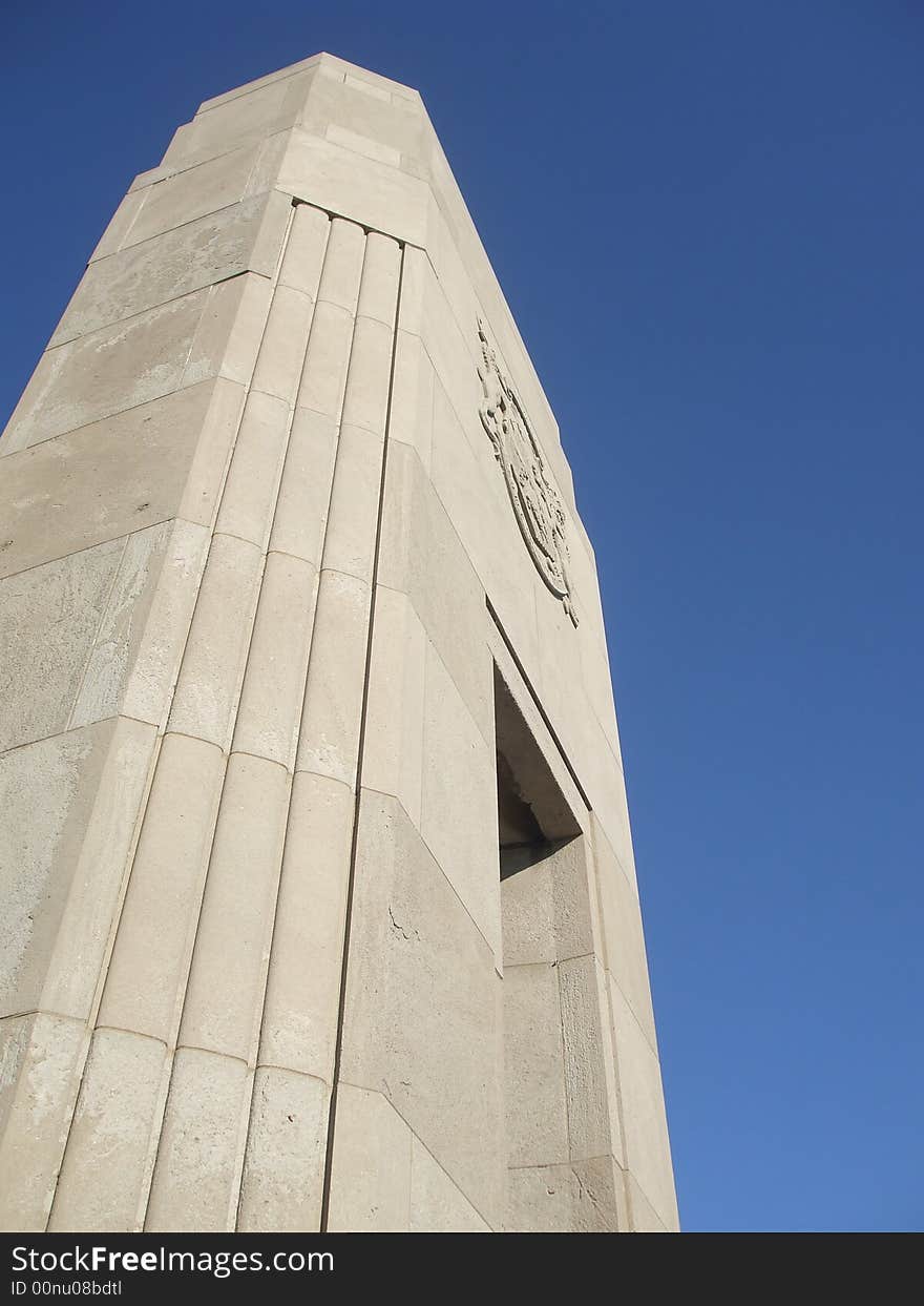 A carved stone pillar against a clear, blue sky. A carved stone pillar against a clear, blue sky.