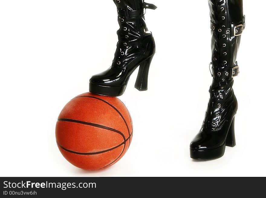 Female legs in thigh high vinyl boots with basketball over white. Female legs in thigh high vinyl boots with basketball over white.